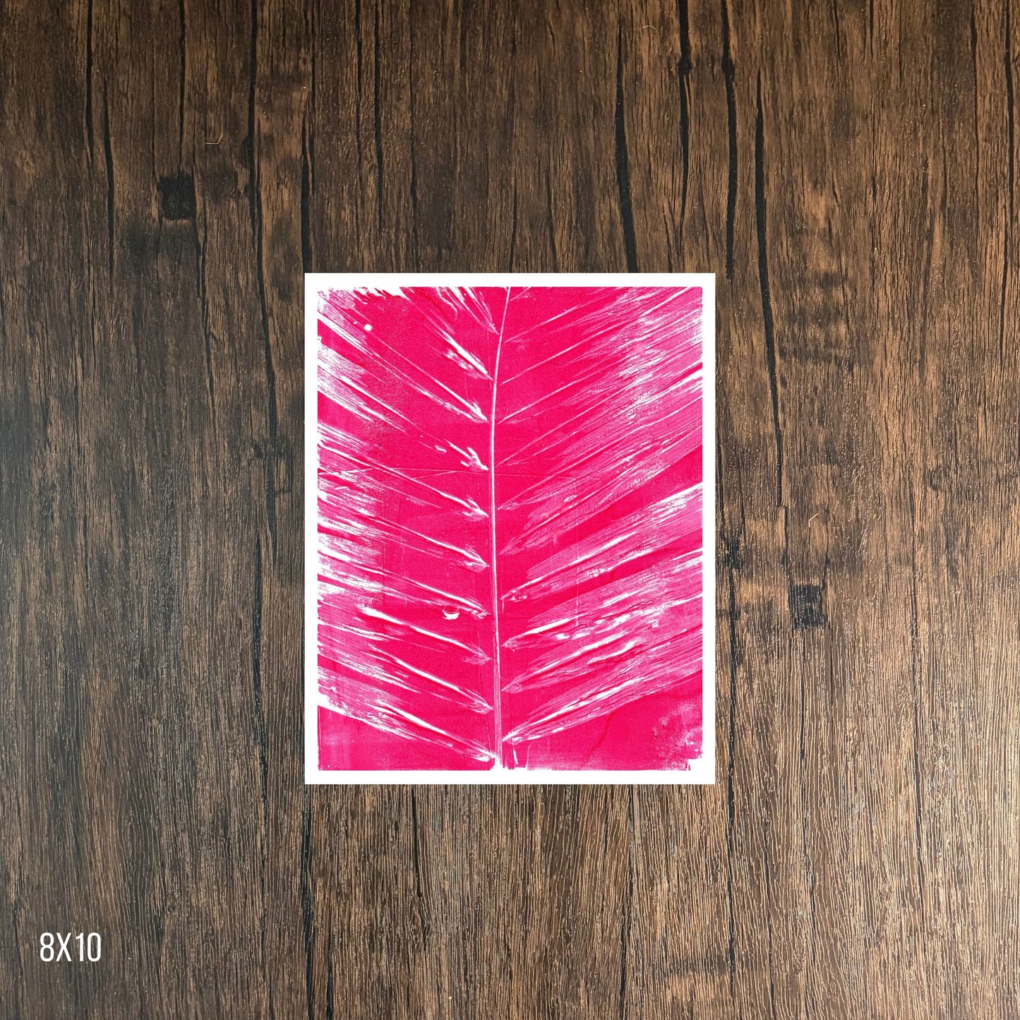 Magenta leaf print on wooden background, 8x10