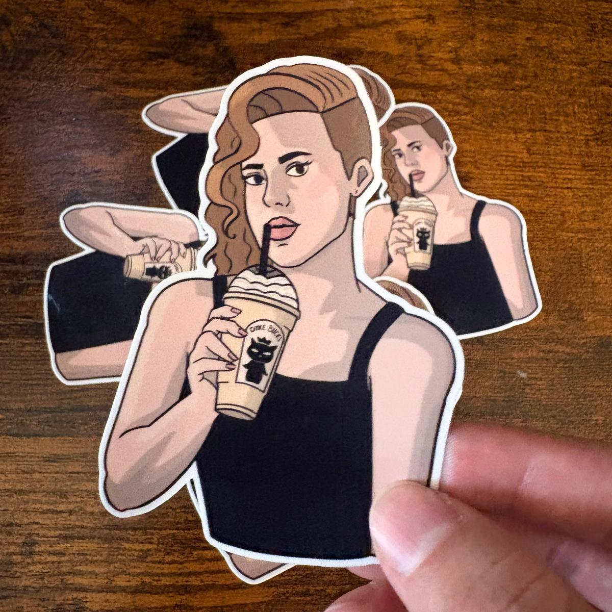 Sticker of woman holding vanilla milkshake with queer coffee shop name